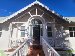 Biały dom z gankiem i drzwiami w obiekcie Caribbean Estates-Montego Bay 12 w mieście Port Edward