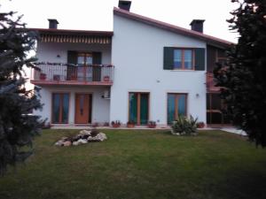 una grande casa bianca con cortile di B&B Carmen Biondani a Pescantina
