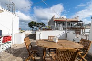un tavolo in legno e sedie sul balcone di una casa di Le Bianche Suites Ostuni a Ostuni