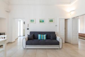 sala de estar blanca con sofá azul en Le Bianche Suites Ostuni, en Ostuni