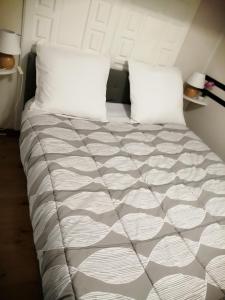 Bett mit weißer Bettwäsche und Kissen in einem Zimmer in der Unterkunft SOUS LE SOLEIL DE PROVENCE in Le Castellet