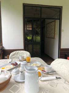 uma mesa com alimentos e bebidas para o pequeno almoço em Gad Gha Kum - El mensajero Lodge em San Ramón