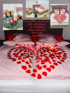 una cama con un montón de corazones rojos en ella en Carpe Diem Privat Guesthouse, en Hermina-major