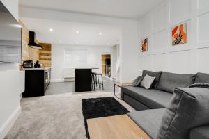 a living room with a couch and a kitchen at Harrow Lodge - Anfield Apartments in Liverpool