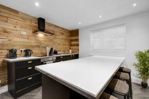 a kitchen with wooden walls and a white counter top at Harrow Lodge - Anfield Apartments in Liverpool