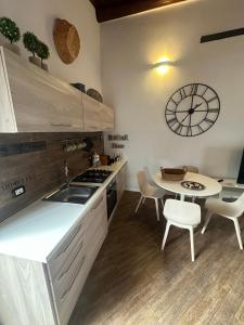 a kitchen with a table and a clock on the wall at Dolce vita al lago in Anguillara Sabazia