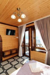 a bedroom with a bed and a tv on a ceiling at Бесаги in Yaremche