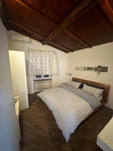 1 dormitorio con 1 cama grande con sábanas blancas en Dolce vita al lago en Anguillara Sabazia