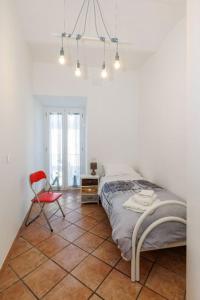 ein Schlafzimmer mit einem Bett und einem roten Stuhl in der Unterkunft La casa di Bianca in Piediluco
