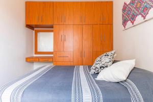 1 dormitorio con 1 cama y armario de madera en Departamento Privado Centro Histórico Guadalajara. en Guadalajara