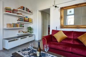 a living room with a red couch and a mirror at THE GRAND VIEW Lux Vatican Suite in Rome