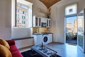 a living room with a red couch and a kitchen at THE GRAND VIEW Lux Vatican Suite in Rome