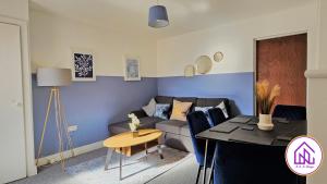 een woonkamer met een bank en een tafel bij Havelock Apartments, City Centre Location in Swindon