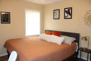 a bedroom with a bed with orange and white pillows at Birchwood Place in Little Rock