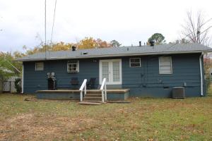 niebieski dom z werandą i tarasem w obiekcie Birchwood Place w mieście Little Rock