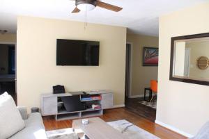 a living room with a couch and a flat screen tv at Birchwood Place in Little Rock