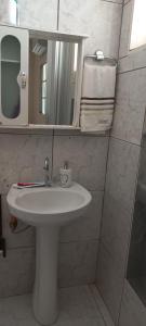 a bathroom with a white sink and a mirror at casa a 5 minutos do aeroporto e Univida in Araraquara