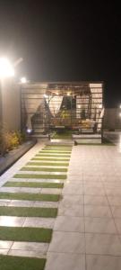 a walkway with a bench at night with grass at شاليهات ميرامار مكة الحسينية in Ash Shishah