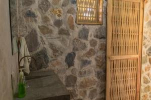 un bagno in pietra con parete in pietra e lavandino di M a r e a V i v a - O a x a Zipolite Altre 37 foto