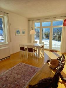 a dining room with a white table and chairs at FLORES, Ferienhaus oder Doppelzimmer, im Grünen, 5 Gehminuten ins Zentrum, Parkplatz, zero emissions in Bad Ischl