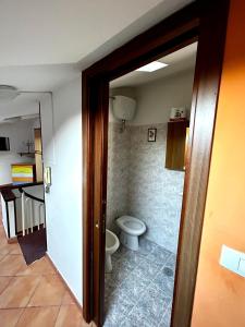 a bathroom with a toilet and a door open at La casa del Nonno in Altavilla Irpina