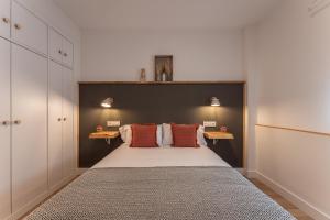 1 dormitorio con 1 cama grande con almohadas de color naranja en Apartamento Turístico KHöALA HOME en Merida