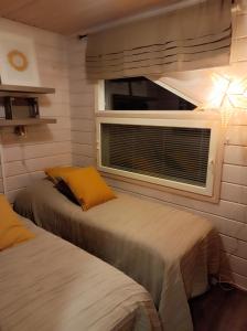 two beds in a room with a window at Unelmasäleikkö 2 in Kittilä