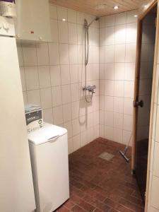 y baño con ducha y pared de azulejos. en Unelmasäleikkö 2 en Kittilä