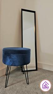 a blue stool sitting in front of a mirror at Redcliffe House, Stylish House Close To Designer Outlet in Swindon