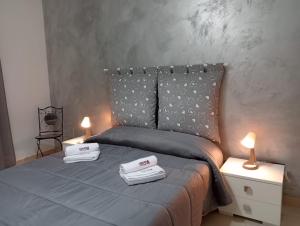 uma cama com duas toalhas e duas velas em sciuliddA Casa Vacanze em Avola