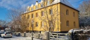 a yellow building with a white car parked in front of it at Villa Küchwald in Chemnitz
