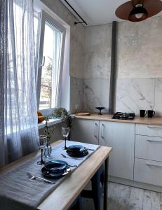 a kitchen with a table with plates and glasses on it at The Cube in Kremenchuk