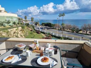 un tavolo con cibo su un balcone con vista sull'oceano di BenalBeach Residential a Benalmádena