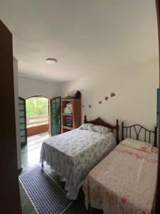 1 dormitorio con 2 camas y ventana en Recanto mato verde, en Caraguatatuba