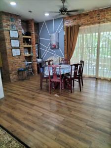 comedor con mesa y sillas en D'Camp Homestay with swimming pool, en Kampong Kenangan