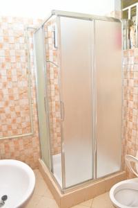 een douche in een badkamer met een wastafel en een toilet bij Makindye Kizungu Holiday Villa in Makindye