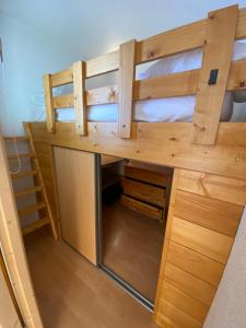a bunk bed with a desk in a room at Charmant T2 montagne ensoleillé in Val Thorens