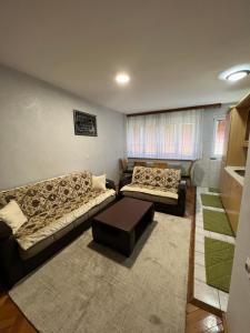 Sala de estar con 2 sofás y mesa en Apartman Crkvice Zenica en Zenica