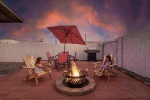 two girls sitting in chairs around a fire pit at Your Downtown Cozy Studio With Backyard Unit C in Phoenix