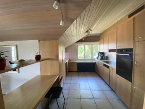 uma cozinha com armários de madeira e uma grande janela em LakeVIEW Penthouse in the heart of Switzerland em Sempach