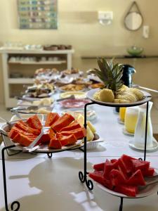 a table topped with plates of fruit on top at Pousada das Galés in Maragogi