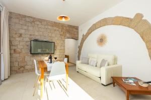 uma sala de estar com um sofá e uma mesa em Scirocco a pochi passi dal mare em Santa Maria Navarrese