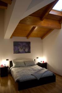 um quarto com uma cama grande e tectos em madeira em CASA VIOLA, deliziosa mansarda in centro storico em Módena