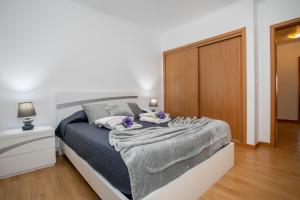 een slaapkamer met een bed met een deken erop bij Casa da Belinha in Ponta Delgada +15 foto's