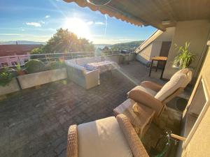 a patio with two chairs and a table on a balcony at LakeVIEW Penthouse in the heart of Switzerland in Sempach
