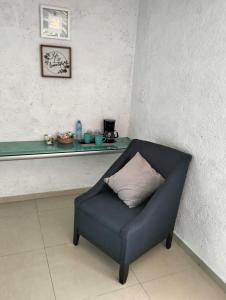 a blue chair with a pillow sitting in a room at Hotel Dos Mundos, Isla Cozumel in Cozumel