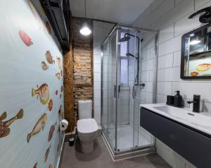 ein Badezimmer mit Dusche, Toilette und Waschbecken in der Unterkunft Cornerstone, apartamento en Casco Viejo in Bilbao + 25 Fotos