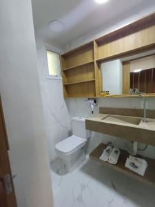 a bathroom with a toilet and a sink and a mirror at LOFTS GREEN ISLAND in Angra dos Reis