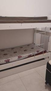a white bunk bed with flowers on it at Apto em Ubatuba divisa com a Praia de Itagua e facil acesso as praias fica ao lado do Atacado Tenda na rodovia Rio Santos in Ubatuba +24 photos