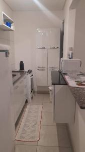 a white kitchen with white counters and white appliances at Apto em Ubatuba divisa com a Praia de Itagua e facil acesso as praias fica ao lado do Atacado Tenda na rodovia Rio Santos in Ubatuba